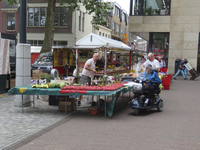 901896 Afbeelding van een standwerker met vers fruit op de zaterdagse warenmarkt op het Vredenburg te Utrecht. Rechts ...